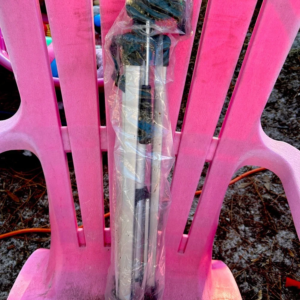 Camera tripod in plastic bag with black carrying bag